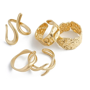 Detail of 5-piece gold lava rings set showing irregular wave patterns and hammered textures