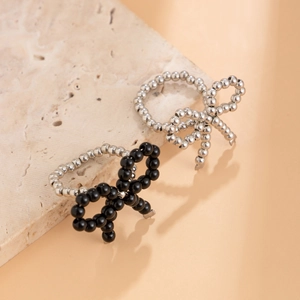 Macro shot of beaded rings featuring metal bow accents in silver and black finishes