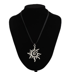 Detalle del colgante de espiral de sol plateado bohemio en un cordón negro