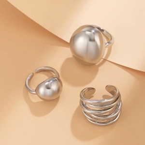 Macro detail of silver geometric molten metal rings featuring ball and multi-layer designs