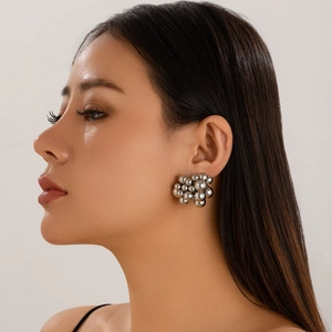 Close-up of geometric silver bead cluster earrings worn by a model in a side profile