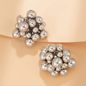 Detail of high-polish silver geometric bead cluster earrings on beige background