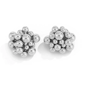 Detailed macro view of silver geometric cluster earrings with polished metal bead stack