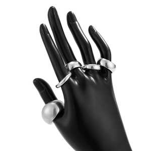 Detailed view of silver irregular lava rings set on black hand model display