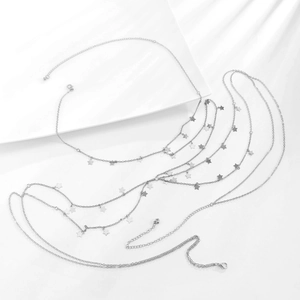 Close-up of multi-layer silver body chain with star charms and lobster clasp detail