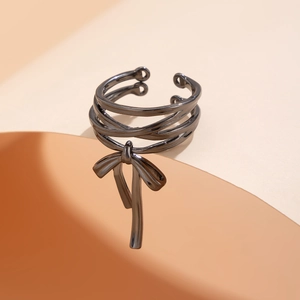 Detail of gunmetal bow ring with multi-layer wrap design and metallic bead accents