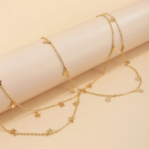 Close-up of golden multi-layer body chain with delicate star pendants on a display stand