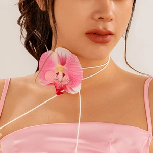 Choker-Halskette mit rosa Orchidee und langen weißen Bändern an einem Damenmodell
