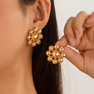 Elegant gold flower earrings made of metallic beads shown on a model and hand
