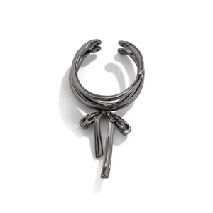 Detailed close-up of gunmetal bow ring featuring a layered band and elegant metallic streamers
