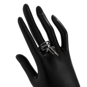 Detailed view of silver bow ring featuring multilayer metal wire design on black hand model