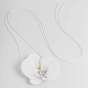 Detailaufnahme des weißen Orchideen-Anhängers mit realistischen Blütenblättern und Kordel