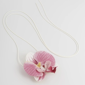 Makro-Detail des realistischen rosa Orchideen-Anhängers mit weicher weißer verstellbarer Kordel