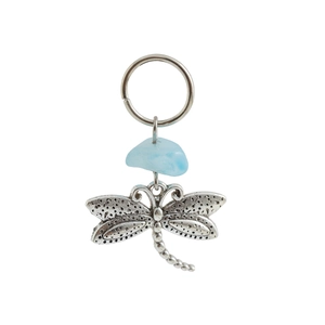 Macro detail of a dragonfly pendant with vintage silver wings and blue gemstone