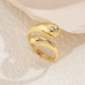 Detail eines polierten goldenen Tropfenrings auf strukturiertem Steinsockel