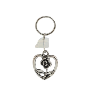 Detail of vintage silver heart keychain with rose engraving and milky white gemstone charm