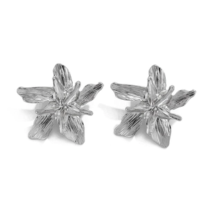 Detail of silver lily flower stud earrings featuring textured petals and a metallic finish