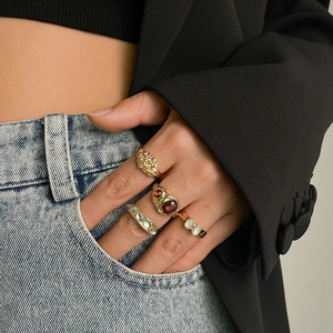 Detail von goldenen Lava-Ringen und Vintage-Edelstein-Ring-Set an der Hand des Models