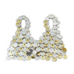 Dettaglio di paillettes metalliche argentate e dorate su un crop top in stile discoteca