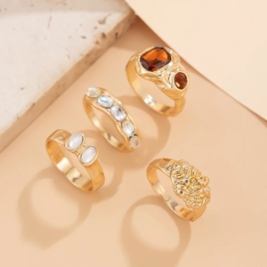 Detailansicht eines Retro-Goldring-Sets mit Bernsteinen und geprägten Texturen