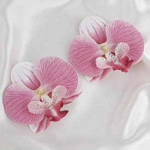 Detailaufnahme von zwei realistischen rosa-weißen Orchideen-Stoffblumen auf Seide