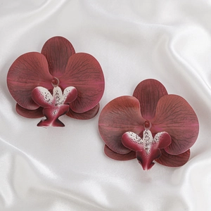 Detailaufnahme von dunkelweinroten Orchideenblütenköpfen mit realistischer Seidentextur