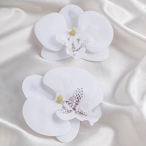 Makro-Detail des weißen Orchideen-Chokers mit Seidentextur auf elegantem Satinstoff