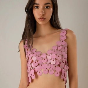 Dettaglio del crop top rosa con paillettes traforate e maglie in anelli di metallo
