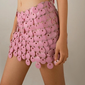 Detail of pink sequin mini skirt with interlocking metal rings and hollow mesh structure