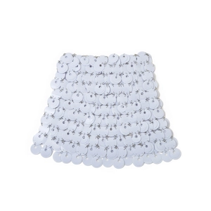 Dettaglio della gonna con paillettes bianche con scaglie rotonde e maglie in metallo