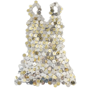 Dettaglio macro di paillettes oro e argento lucide collegate da anelli metallici sull'abito