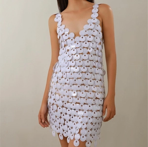 Detailed view of white sequin mini dress featuring hand-linked round discs and V-neckline
