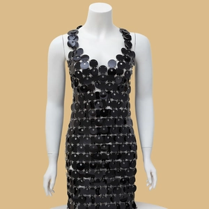 Detailed view of black sequins linked by metal rings on a hollowed-out dress