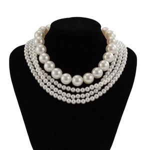 Detalle de collar de perlas multicapa con colgante grande en busto de terciopelo negro