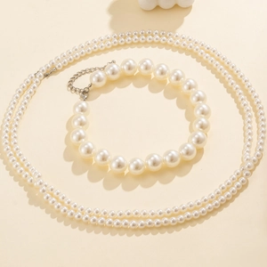 Detalle de elegante conjunto de collar de perlas multicapa y pulsera con cierre