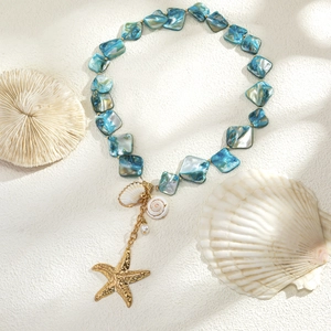 Close-up of ocean-style necklace with starfish, seashell pendants and blue beads