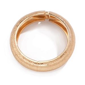 Detailopname van de gouden geribbelde armband met een handige scharniersluiting