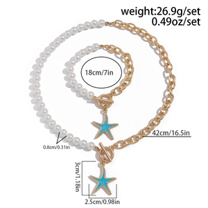 Dettaglio del set di perle e catena dorata con fibbia OT e ciondolo a stella marina blu