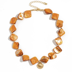 Detail of orange shell bead necklace with a golden scallop pendant and adjustable chain