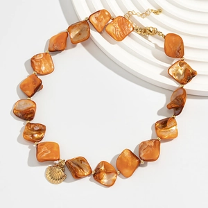 Macro view of bohemian necklace with brown shell beads and golden seashell pendant detail