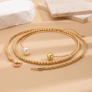 Detailed view of gold multi-layer necklace set with pearls and twisted rope textures