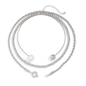Detailed close-up of layered silver necklace set with twisted chain and faux pearl accents