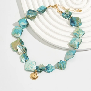 Detail of bohemian seashell choker with turquoise beads and golden shell pendant