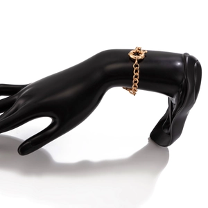 Detailed view of a gold-plated link bracelet with large sailor clasp on a model wrist