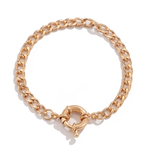 Macro detail of golden chunky curb chain bracelet featuring a large spring ring clasp