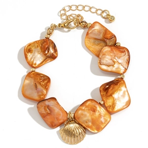 Detail of beaded necklace with orange shell pieces and golden scallop charm pendant