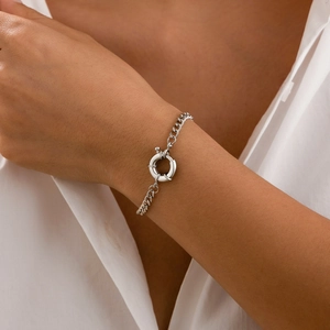 Close-up of a silver Cuban link bracelet with a large sailor clasp on a model's wrist