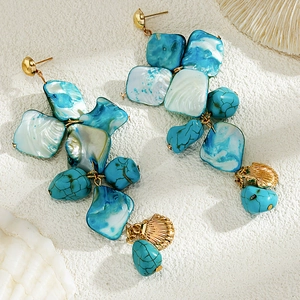 Detail of beach-style long drop earrings with blue resin shells and turquoise beads