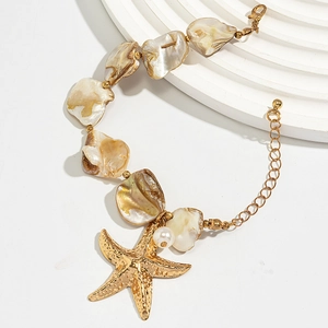 Macro shot of seashell necklace with golden starfish pendant and white pearl details