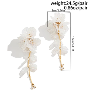 Vue détaillée de grandes boucles d'oreilles fleurs irisées blanches avec mesures